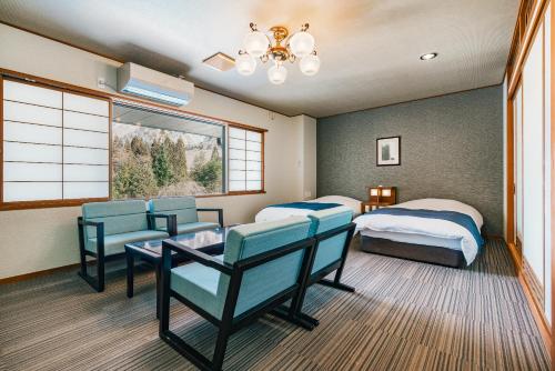 a bedroom with two beds and a table and chairs at Hirayukan in Takayama