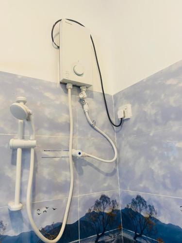 a bathroom with a shower head and a wall at Wishwa Villa in Weligama
