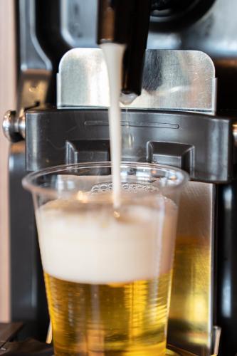 a beer is being poured into a glass at La Vista Kusatsu Hills in Kusatsu