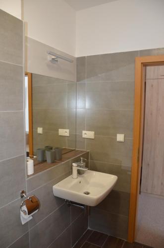 a bathroom with a sink and a mirror at Penzión Rocket Club in Lučenec