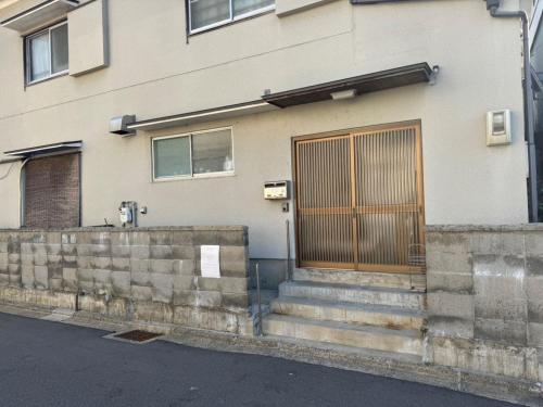 a building with a wooden door and some stairs at Kyoto151 in Kyoto