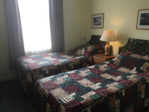 two beds in a hotel room with a quilt at Dukes Head Inn in Richmond upon Thames