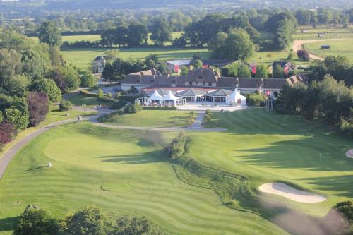 an aerial view of a golf course with a large house at Amirauté Hôtel Golf Deauville in Deauville