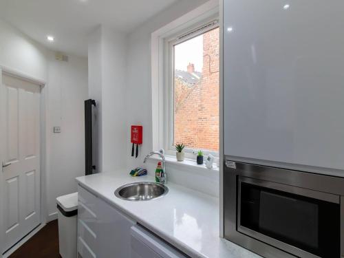 a kitchen with a sink and a window at Grosvenor 126 Trendy Jesmond Whole Apartment in Jesmond