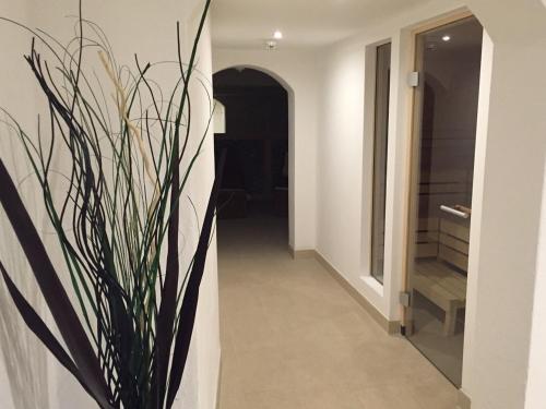 a hallway with a vase with a plant in it at first mountain Hotel Zillertal in Aschau