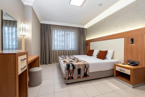 a hotel room with a bed and a television at Villa Sunflower Hotel - All Inclusive in Alanya