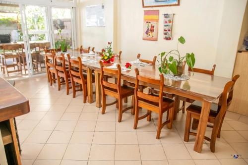 a dining room with a large wooden table and chairs at Chez Jenny port Mathurin in Rodrigues Island