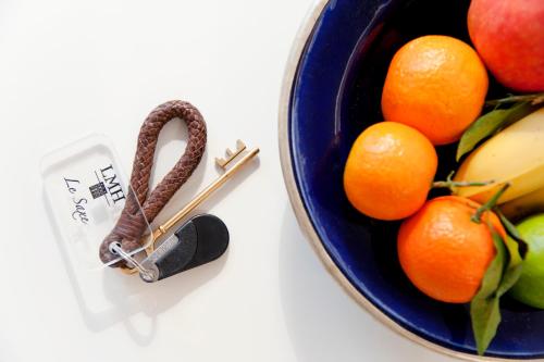 a bowl of fruit with a pair of knitting needles and oranges at MHL - Maison Hotel Lyon in Lyon
