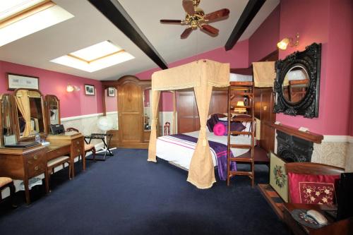 a bedroom with pink walls and a bed with a desk at The PitStop in Bishops Stortford