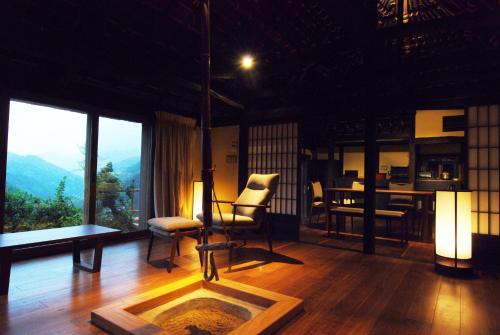 a living room with a table and chairs and a view at Tougenkyo Iya no Yamazato in Miyoshi
