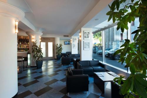 a lobby with couches and a bar with plants at CDH Hotel La Spezia in La Spezia