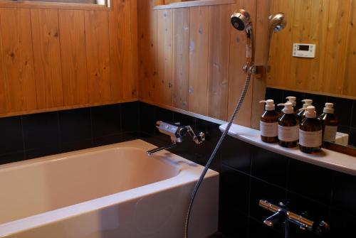 a bathroom with a bath tub with a shower at Tougenkyo Iya no Yamazato in Miyoshi
