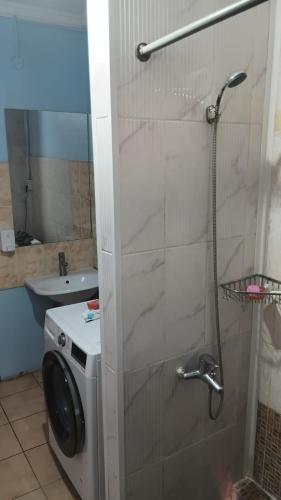 a bathroom with a shower and a washing machine at Гостиница"Hostel" in Karagandy