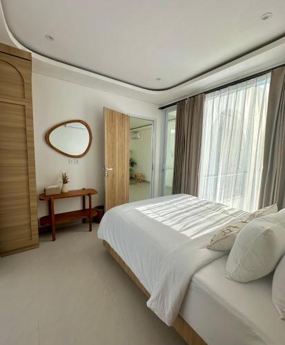 a bedroom with a large bed and a window at Villa Lipa in Ungasan