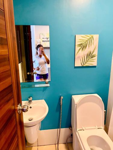 a woman taking a picture of a bathroom at Horizons 101-Premium Studio 42J in Cebu City