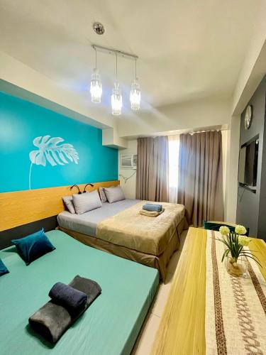 a bedroom with two beds and a blue wall at Horizons 101-Premium Studio 42J in Cebu City