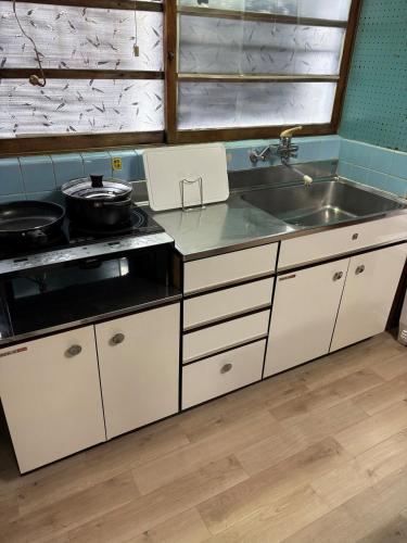 a kitchen with a stove and a sink at 日牟禮乃宿 日牟禮八幡宮徒歩4分ラコリーナ車4分 in Omihachiman