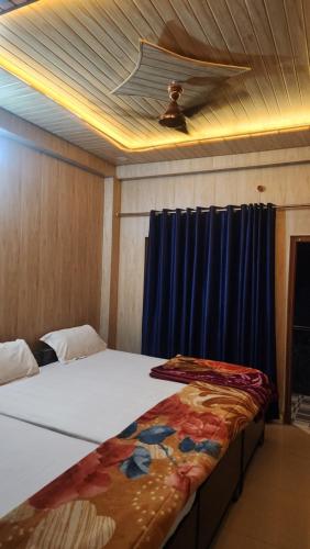 a bedroom with a large bed with a blue curtain at Krishna guest house in Mussoorie