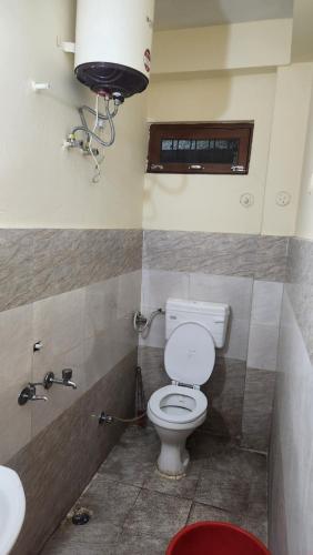 a bathroom with a toilet and a sink at Krishna guest house in Mussoorie
