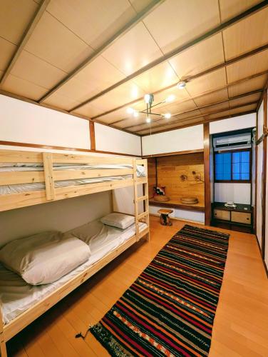 a bedroom with bunk beds and a rug at Kaido Urasa CoLiving in Minami Uonuma