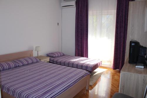 two beds in a room with a window at Casa Agava Becici in Bečići