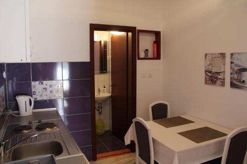 a kitchen with a table and a sink and a table and a table at Casa Agava Becici in Bečići
