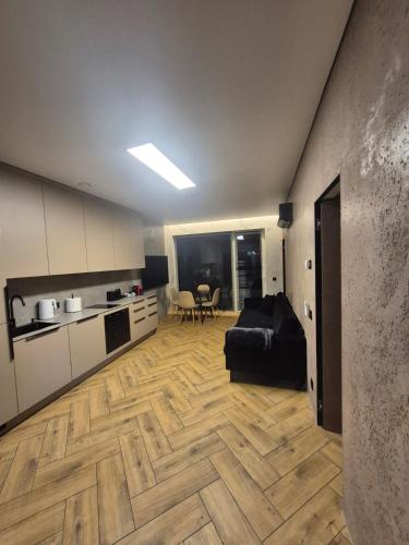 un soggiorno con un divano nero e una cucina di Marių namai a Kaunas