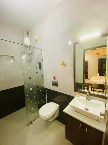 a bathroom with a toilet and a sink and a mirror at Dreamland View Resort in Cochin