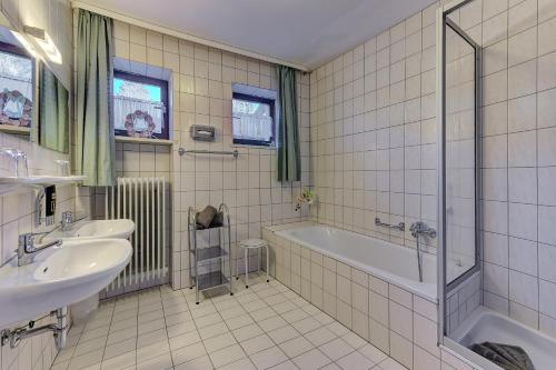 a bathroom with a tub and a sink and a bath tub at Hotel Haus Anna in Bayerisch Eisenstein