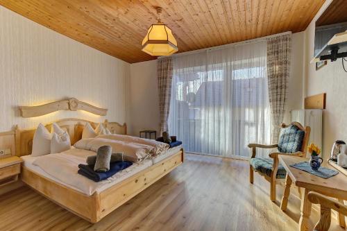 a bedroom with a large bed and a table and a desk at Hotel Haus Anna in Bayerisch Eisenstein