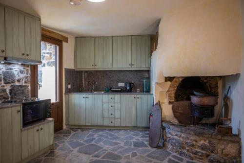 a kitchen with a stone oven in the middle at Stone Olympi Lodges - Chios Cozy Hideaways in Olýmpoi
