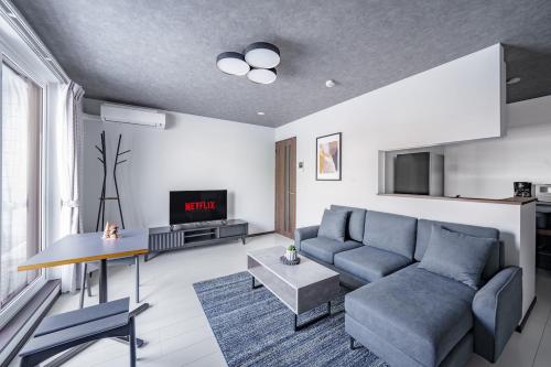 a living room with a couch and a table at Hills Niseko 105 in Niseko