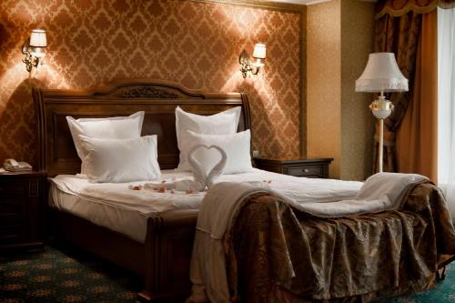 a bedroom with a large bed with white pillows at Diplomat Hotel by AG Hotels Group in Astana