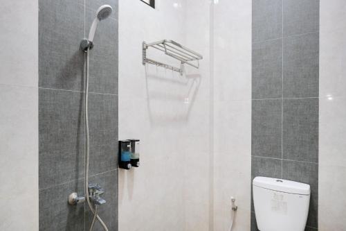 a bathroom with a shower and a toilet at RedDoorz at Jestro Guest House Batu in Tlekung