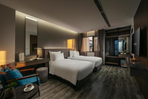 a hotel room with two beds and a television at GrandView Hotel & Residence Hanoi in Hanoi