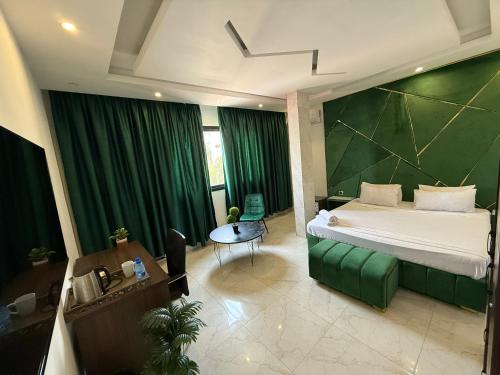 a bedroom with a bed and a green wall at Hôtel Phoenicia in Brazzaville