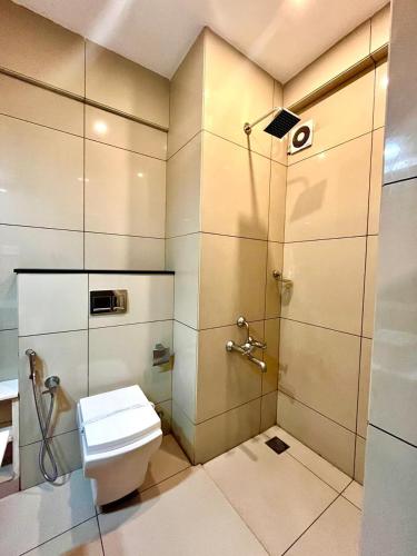 a bathroom with a shower and a toilet in it at Mareena Regency in Cochin