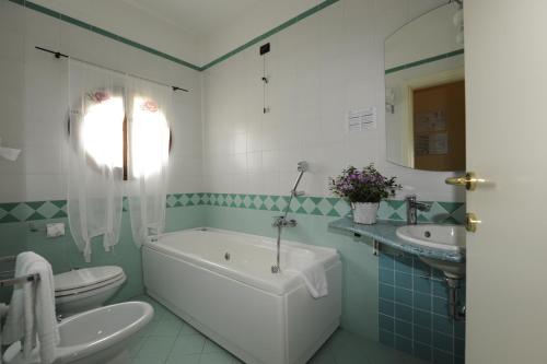 a bathroom with a tub and a toilet and a sink at Hotel Sextum in Bientina