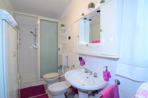 a white bathroom with a sink and a toilet at Casa Michelangela in Mascali