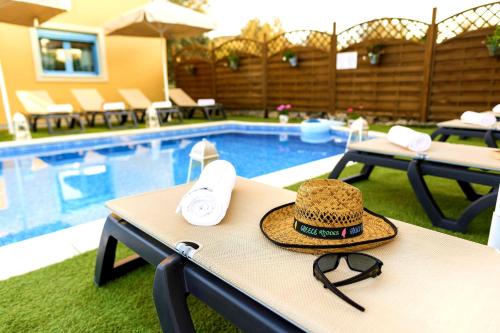 a hat sitting on a table next to a swimming pool at Lindos Luxury Retro Villas in Lindos
