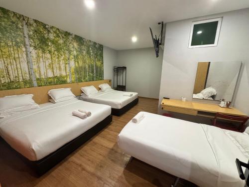 a room with three beds and a mirror at Tropical Villa Kuantan in Kuantan