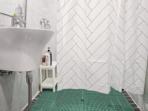 a bathroom with a sink and a shower with a green rug at Your Stay in Seoul