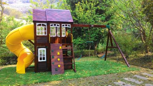 a small playground with a slide and a play structure at Natural Residence B&B in Taian