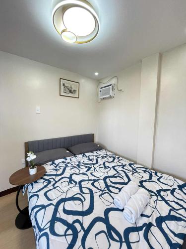 a bedroom with a bed with a blue and white blanket at Potot Haven Dorm and Transient in Libmanan