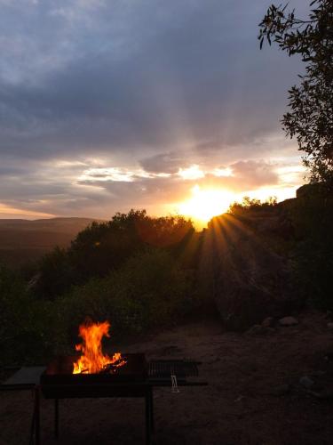 a fire pit with the sunset in the background at Nardouw in Clanwilliam