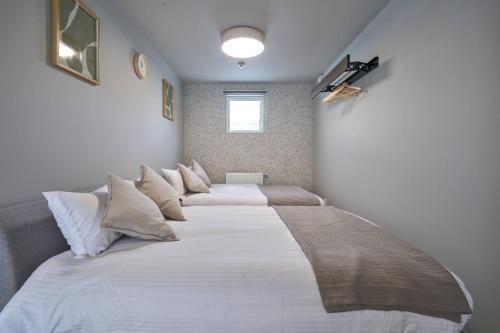two beds in a room with white sheets and pillows at Niseko Town Retreat ONYX in Kutchan