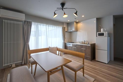 a kitchen and living room with a table and chairs at Niseko Town Retreat ONYX in Kutchan