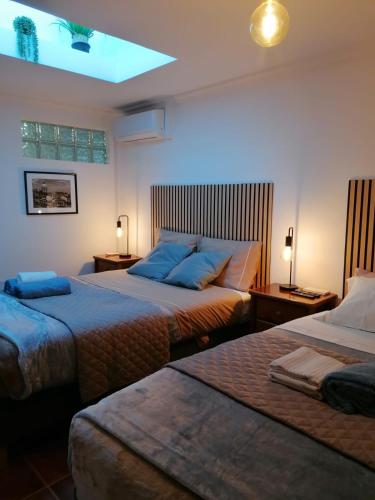a bedroom with two beds and a light on the ceiling at 9, Cimo da Aldeia in Aldeia de João Pires