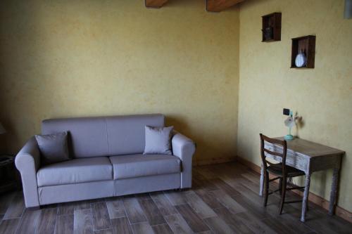 a living room with a couch and a table at Azienda Agricola Garoglio Davide in Alfiano Natta