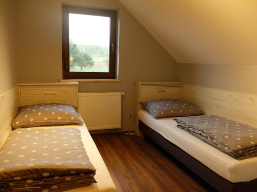 2 camas en una habitación pequeña con ventana en Apartament Pozytywka, en Tenczynek
